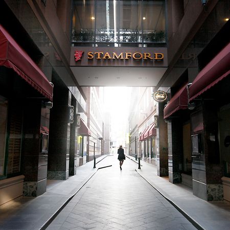 Stamford Plaza Melbourne Hotell Exteriör bild The photo depicts a narrow alley or passageway, possibly in an urban setting. On one side, there are storefronts with canopies, and on the opposite side, there is a prominent sign reading "STAMFORD." The pathway is lined with buildings, creating a se