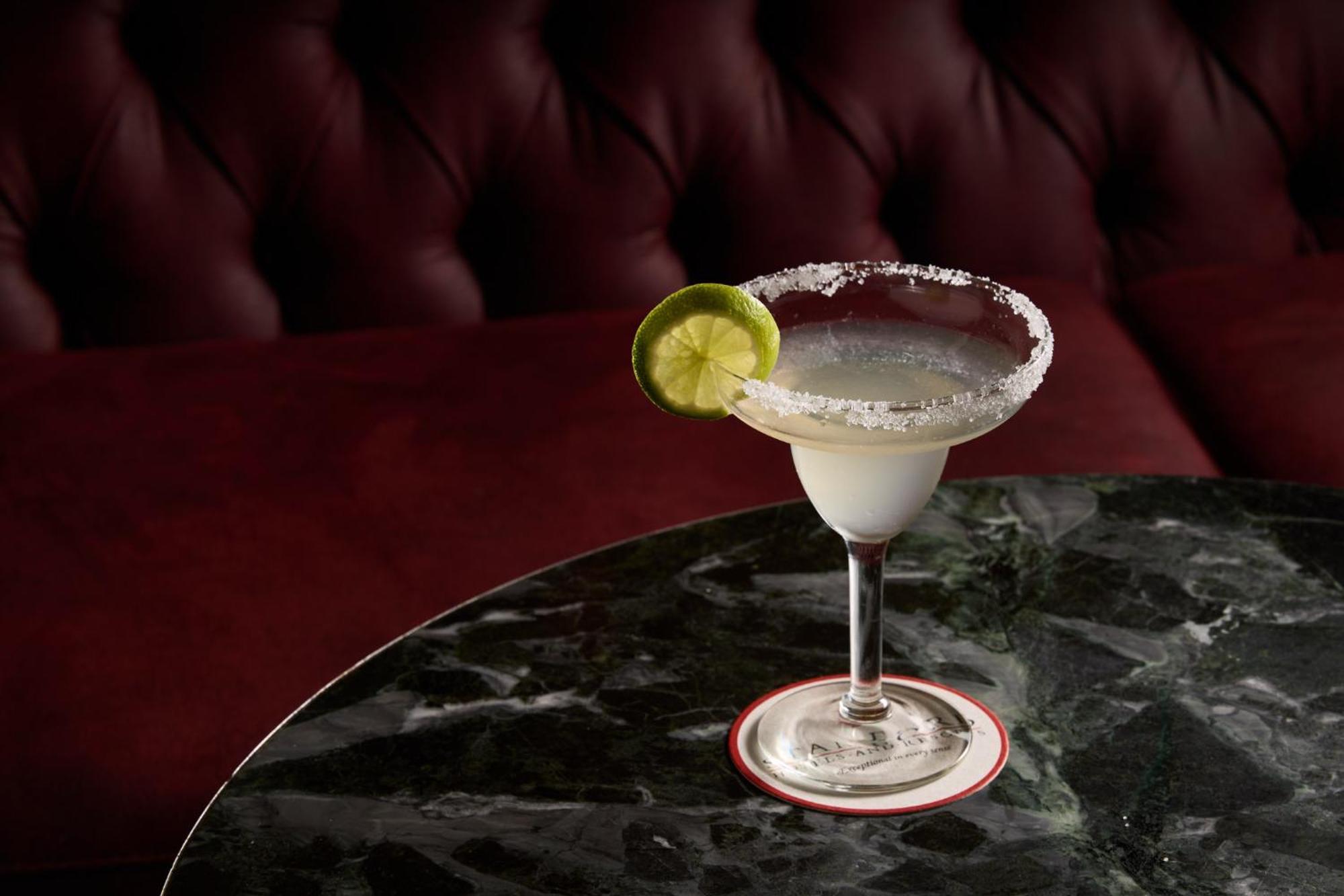 Stamford Plaza Melbourne Hotell Exteriör bild The photo shows a beautifully presented margarita cocktail served in a classic margarita glass. The drink is clear with a salt rim around the edge, and adorned with a slice of lime. The glass is placed on a dark green marble table, contrasting with a