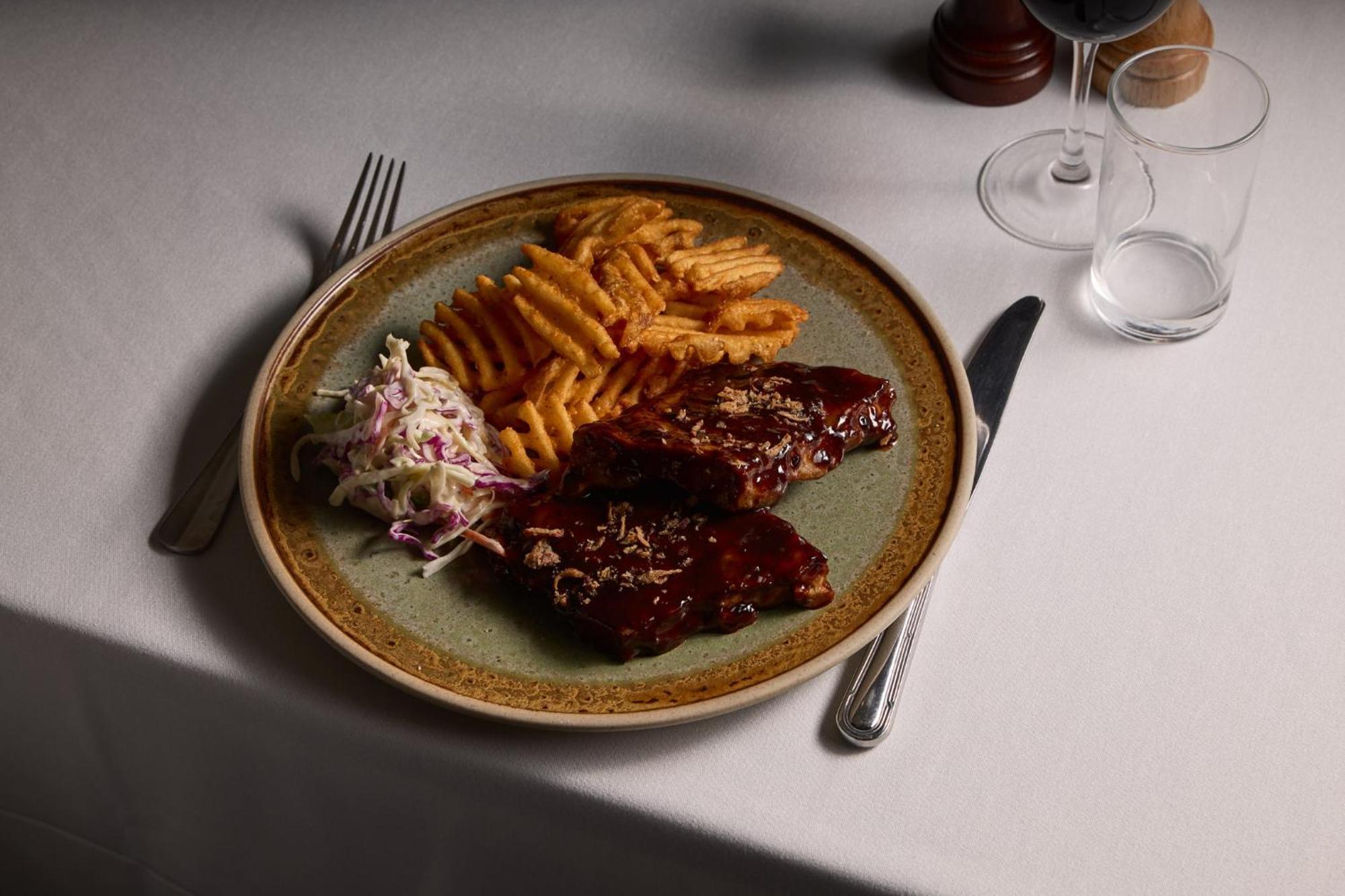 Stamford Plaza Melbourne Hotell Exteriör bild The photo displays a plate of food featuring two pieces of steak that appear to be glazed with a rich sauce. Alongside the steak, there are crinkle-cut fries arranged neatly on one side of the plate. Additionally, there's a small serving of coleslaw,
